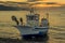 A lone fishing vessel beached on the shore of Castell de Ferro, Spain at sunrise