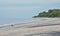 Lone girl sits on a beach for some alone time, but takes her cell phone with her.