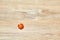 Lone half cherry tomato on a wooden table surface