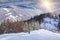 Lone hiker with a backpack walking along the trail in the winter mountains.