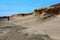 A lone hiker walks along arid petrified volcanic lava desolate landscape in El Medano, Tenerife