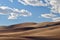 A lone hiker walks the ridge at Great Sand Dunes National Park on a sunny day