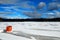 A lone ice fishing shack stands on a frozen lake