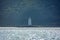 A lone lighthouse is seen in the fog against the backdrop of rainforest, mountains and clear turquoise sea on the coast of Yalong