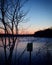 Lone mailbox near serene lake during sunset