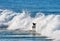 A lone male surfer holds his poise, after succesfully floating the foamies - or riding the whitewater of a large broken wave.