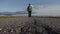 lone male traveler walks along a deserted asphalt automobile country road on a summer day