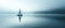 A Lone Man Sailing Peacefully On A Serene And Misty Lake