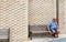 A lone man sits on a bench.