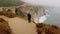 Lone man stands near dramatic cliffs at Big Sur, next to Bixby Creek Bridge