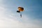 A Lone Parachutist sailing through a blue sky