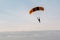 A Lone Parachutist sailing through a cloudy blue sky