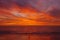 Lone person on beach faces a glorious sunset