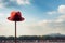 Lone red hat atop pole, sharply contrasts with blurred surroundings