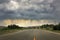 Lone road with threatning dark rain clouds