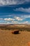 Lone rock on the edge of a flat land with distant hills and beautiful cloudscape, Wahweap. Beautiful Colorado river basin, Arizona
