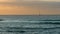 Lone sailboat floats on the horizon in sunset dramatic sunlight. The concept of romance, loneliness