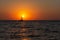A lone sailboat at sunset. Atmospheric seascape with orange sun