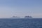 A lone sailboat with vivid red sail, gracefully navigates the calm North Sea near the Lofoten Islands, with mist-veiled mountain