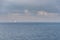 A lone sailing boat at sea in the Oresund Strait suggests relaxation. Sailboat in the ocean conveys tranquillity and serenity