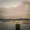 A lone seagull at a pier. Small boats anchored nearby, Retro style