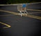 A Lone shopping cart in an empty parking lot