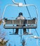 Lone skier in a chair lift at a winter sports resort