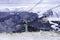 A lone skier climbs the mountains on a cable car for descent.