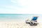 A lone sun lounger stands on the seashore right next to the water