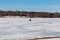 Lone tent for ice fishing on frozen lake with traffic marks on frozen lake surface