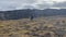 A lone tourist with a large backpack walks through the tundra fields of Kamchatka