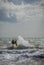 Lone unrecognizable kiter in the stormy sea on the beach of Marina di San Nicola in Italy