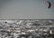 Lone unrecognizable kiter in the stormy sea on the beach of Marina di San Nicola in Italy