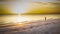 A lone visitor to the beach witnesses a dramatic sunset