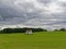 A lone white lime stained stone Doocot or Dovecot in a Field of newly sown wheat in farmland