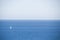 Lone white sailboat on a stretch of a bright blue sea. Sunny day. Mediterranean sea.