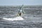 Lone windsurfer in the stormy sea catching a wave