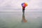 Lone woman at the beach with colorful umbrella