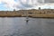 Lone yacht passes by the Valletta skyline on an overcast and cloudy day