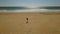 Lone young woman walking on a deserted beach