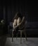 Loneliness woman sit with her knees bent on wooden chair