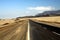 Lonely asphalt road through barren waste land into endlessness of Atacama desert, Chile