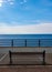 Lonely banch. Summer days in the village of Etretat. Picturesque beach, promenade, boats. Upper Normandy, France.