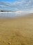 Lonely beach with focus on pristine sand and the waves