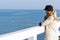 Lonely beautiful sad girl is standing on the pier on a sunny warm autumn evening at the sea