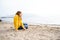 Lonely beautiful sad girl teenager sits thoughtfully on sand sea beach. Dreams,anxiety,worries about future,school