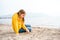 Lonely beautiful sad girl teenager sits thoughtfully on sand sea beach. Dreams,anxiety,worries about future,school