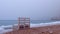 A lonely bench stands on the shore of the sea beach.