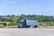 Lonely big rig dark semi truck with semi trailer stands in spacious parking lot