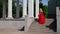 lonely blonde woman in gorgeous red dress with rose in hand is walking over stairs